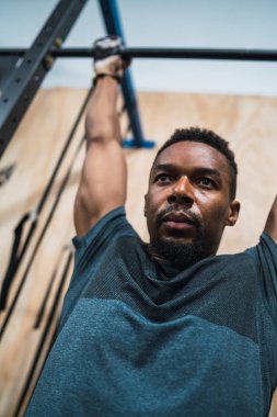 Sporcu adam spor salonunda egzersiz yapıyor..