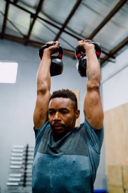 Atletik adam Crossfit kettlebel ile egzersiz yapıyor..