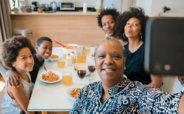 Familia multigeneracional tomando selfie con teléfono en casa. —  Fotos de Stock