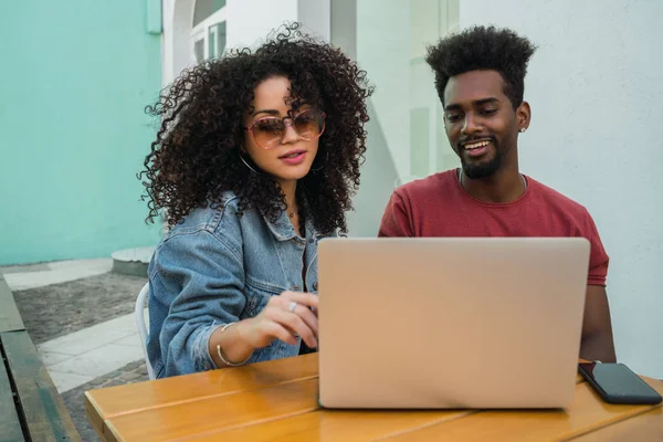 Due amici afro utilizzando il computer portatile in una caffetteria. — Foto Stock