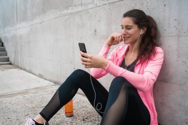 Atletik kadın telefonunu kullanıyor..