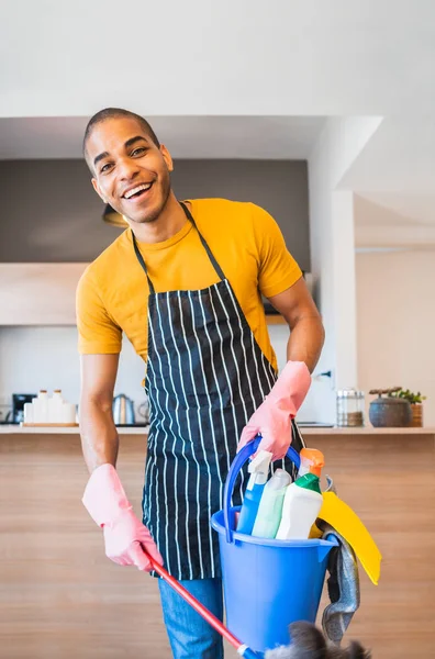 Lateinischer Mann mit einem Eimer mit Putzutensilien. — Stockfoto