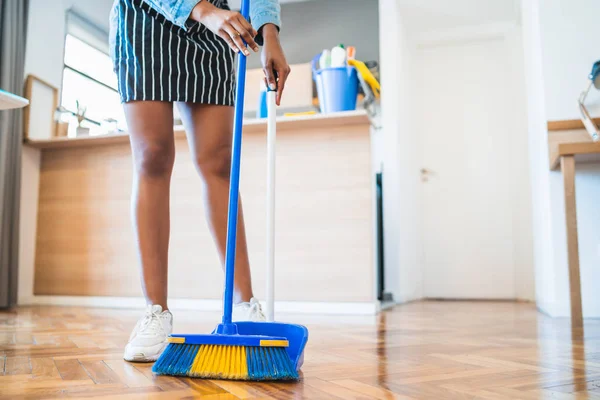 自宅でほうきで床を掃除アフロ女性. — ストック写真
