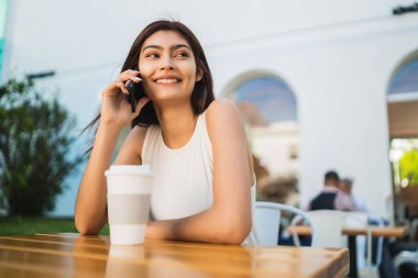 Genç Latin kadın telefonda konuşuyor..