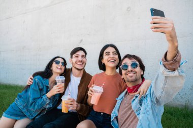 Bir grup arkadaş telefonla selfie çekiyor..