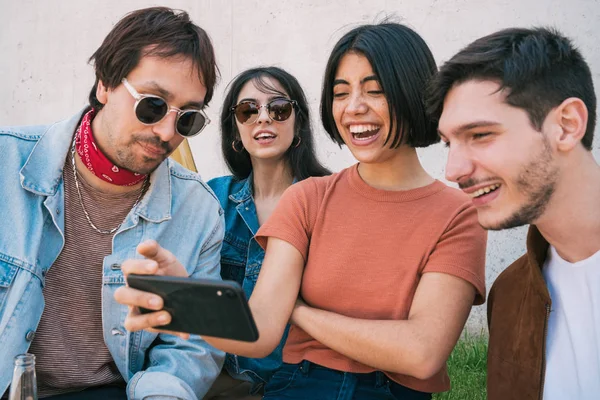 Группа друзей смотрит что-то в смартфоне. — стоковое фото