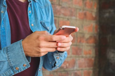 Genç adam cep telefonunu açık havada kullanıyor..