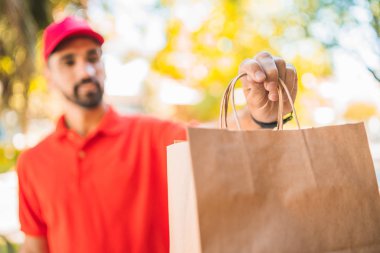 Eve teslimat yaparken paket taşıyan teslimatçı..