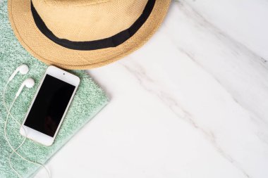 Akıllı telefon, şapka, güneş kremi ve havlu..