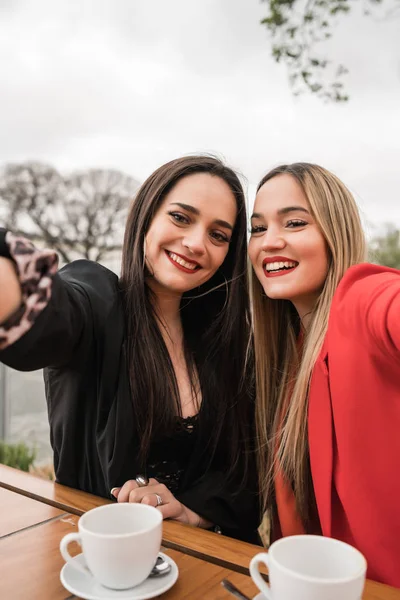 Dois jovens amigos tirando uma selfie juntos no café. — Fotografia de Stock