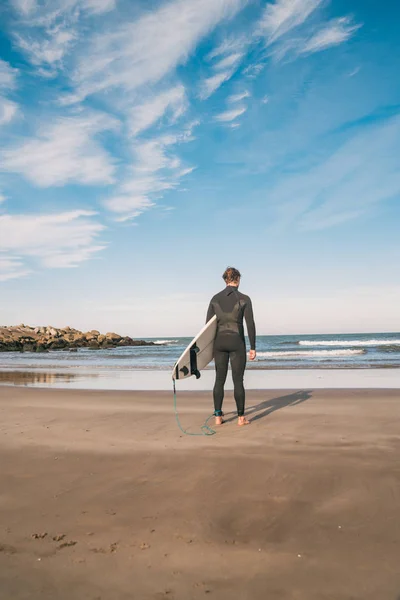 Surfer het water in met zijn surfplank. — Stockfoto
