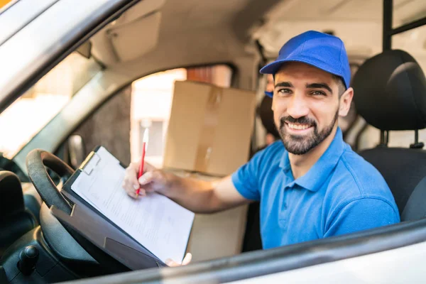 Entrega homem verificando lista de entrega em van. — Fotografia de Stock