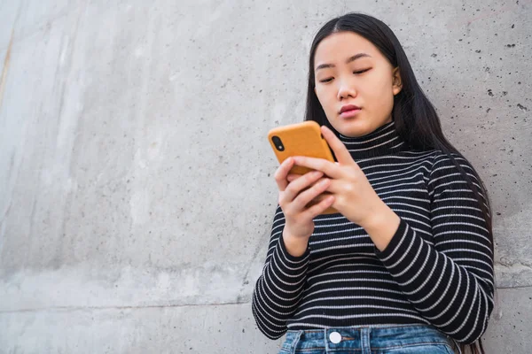 Mujer asiática usando su teléfono móvil. —  Fotos de Stock