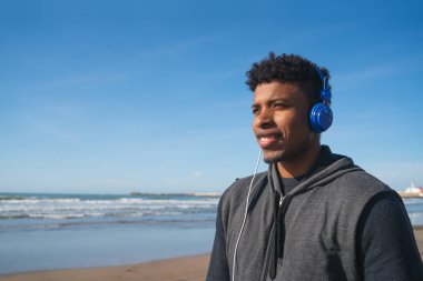 Müzik dinleyen atletik bir adam.