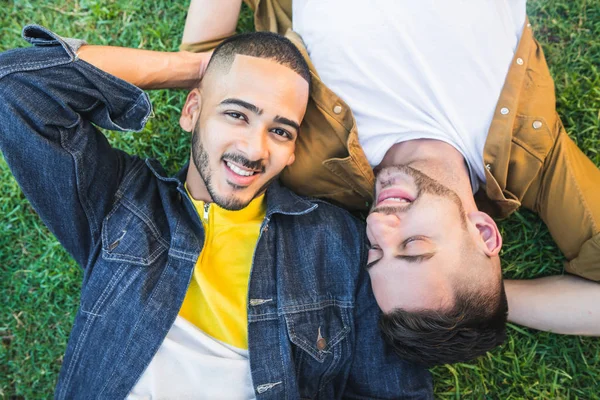 Schwules Paar legt sich auf das Gras im Park. — Stockfoto