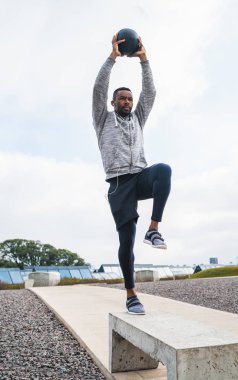 İlaç topuyla atletik adam eğitimi.