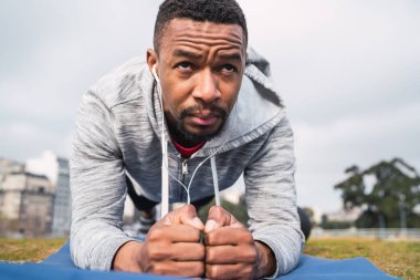 Atletik adam parkta egzersiz yapıyor..