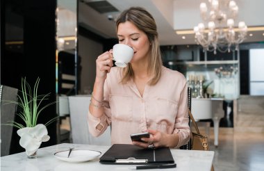 businesswoman using her mobile phone at hotel lobby.