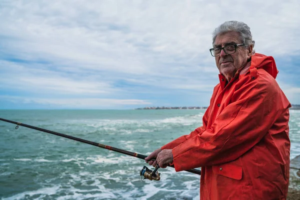 Yaşlı adam denizde balık tutuyor.. — Stok fotoğraf