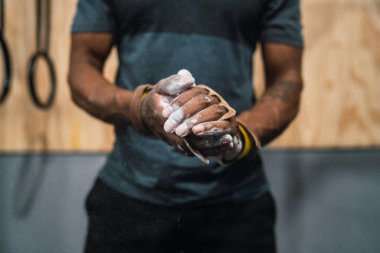 Fitness adamı tebeşir magnezyum tozuyla ellerini ovuşturuyor..
