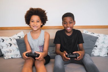 Evde video oyunu oynayan iki kardeş..