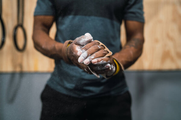 Fitness man rubbing hands with chalk magnesium powder.