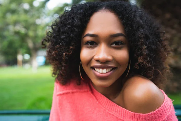 Afro-americká žena sedí v parku. — Stock fotografie