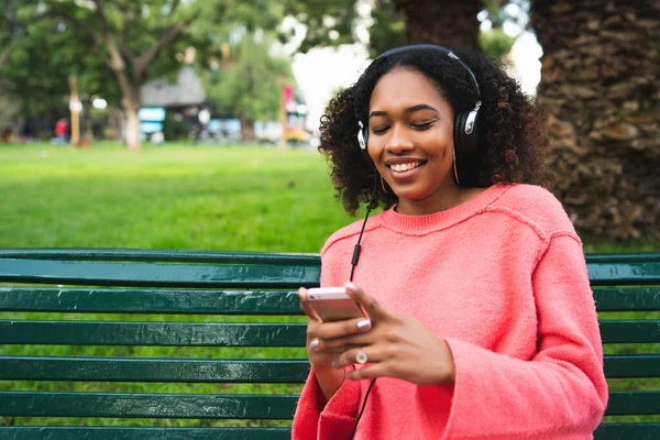 Afro-amerikai nő zenét hallgat telefonnal. — Stock Fotó