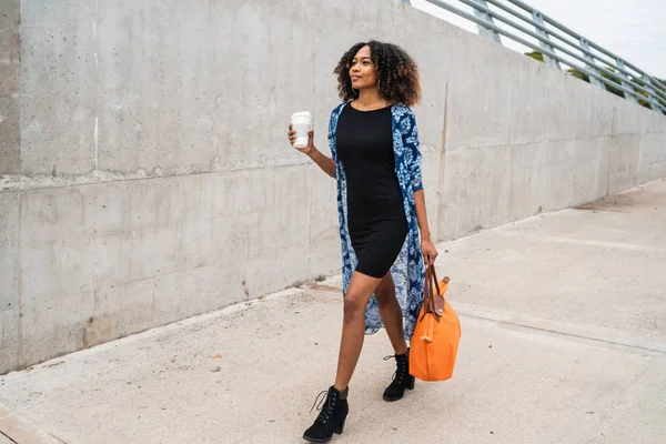 Afro amerikansk kvinna promenader med kaffe. — Stockfoto