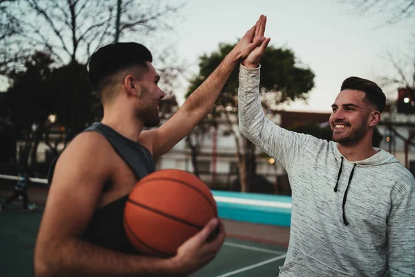 Två unga vänner spelar basket. — Stockfoto