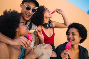 Çok ırklı arkadaş grubu yemek yerken tatilin tadını çıkarıyor.