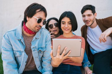Açık havada dijital tablet kullanan arkadaşlar.