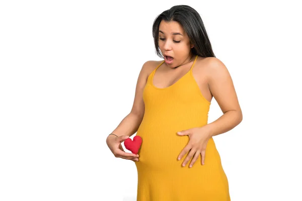 Mulher grávida segurando sinal de coração na barriga. — Fotografia de Stock