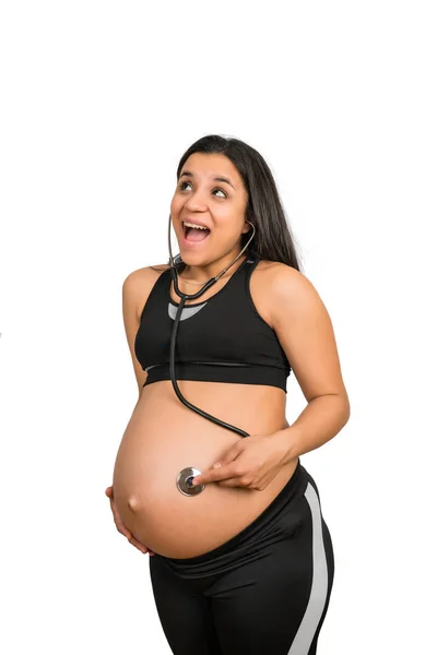 Mulher grávida com estetoscópio na barriga ouvindo o bebê .. — Fotografia de Stock
