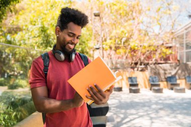Afro üniversite öğrencisi onun kitabını okuyor ve okuyor..