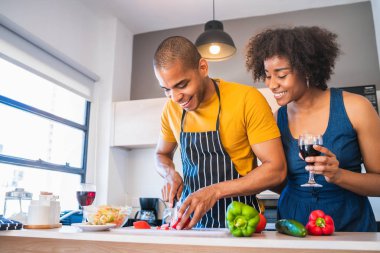 Latin çift mutfakta birlikte yemek pişiriyor..