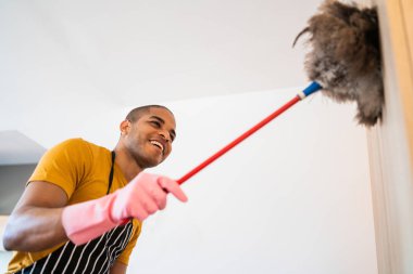 Genç Latin adam yeni evinin tozunu alıyor..