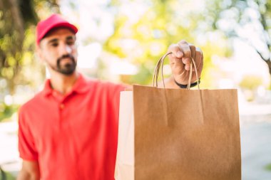 Paket taşıyan bir teslimatçının portresi müşterisine teslimat yaparken. Teslimat ve nakliye konsepti.