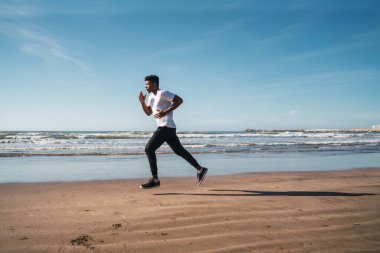 Sahilde koşan atletik bir adamın portresi. Spor, spor ve sağlıklı yaşam tarzı..