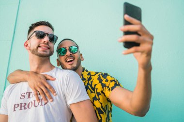 Mutlu eşcinsel çiftin portresi. Birlikte zaman geçirip cep telefonuyla selfie çekiyorlar. Lgbt ve Aşk Konsepti.