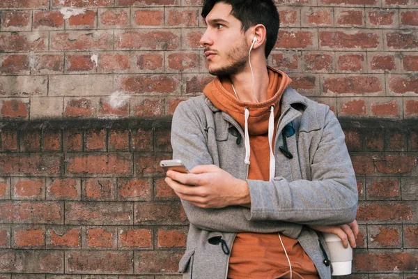 Ritratto Giovane Uomo Con Cuffie Utilizzando Telefono Cellulare Contro Muro — Foto Stock