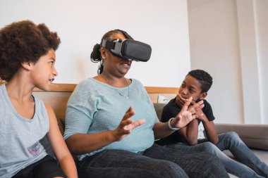 Evde VR gözlükleriyle oynayan Afrikalı Amerikalı büyükanne ve torunların portresi. Aile ve teknoloji kavramı.
