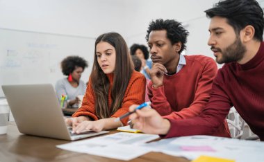 Genç yaratıcı tasarımcılar bir projede çalışıyor ve işyerindeki yeni düzen gelişimini tartışıyorlar. İş konsepti.