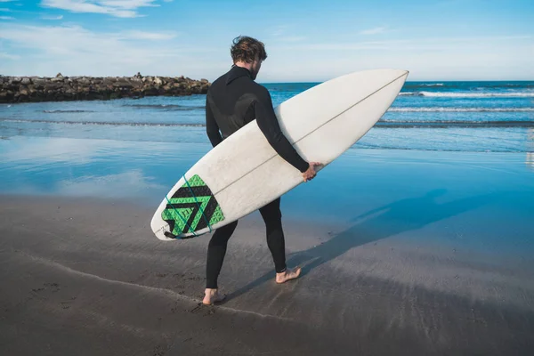 Der Junge Surfer Steigt Mit Seinem Surfbrett Einem Schwarzen Surfanzug — Stockfoto