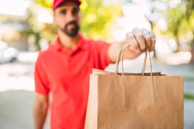 Paket taşıyan bir teslimatçının portresi müşterisine teslimat yaparken. Teslimat ve nakliye konsepti.