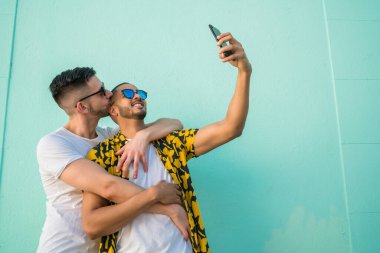 Mutlu eşcinsel çiftin portresi. Birlikte zaman geçirip cep telefonuyla selfie çekiyorlar. Lgbt ve Aşk Konsepti.