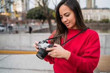 Açık havada profesyonel dijital kamera kullanan genç fotoğrafçı kadının portresi. Fotoğraf konsepti