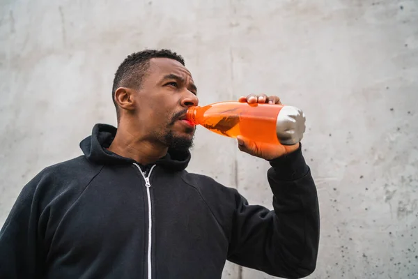 Porträtt Atletisk Man Dricka Något Efter Träning Mot Grå Bakgrund — Stockfoto