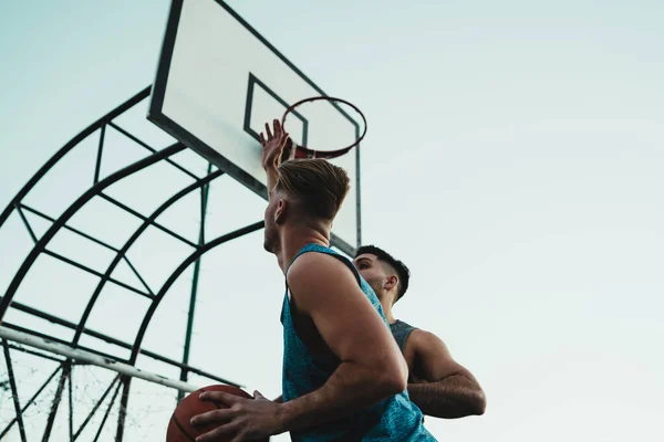 Young basketball players playing one-on-one on outdoor court. Sport and basketball concept.