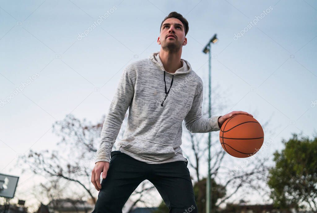 Portrait of young basketball player playing outdoors. Sport concept. Basketball concept.